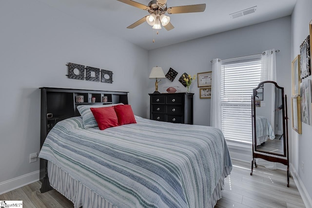 bedroom featuring baseboards, wood finished floors, and a ceiling fan