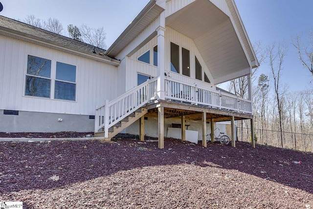 rear view of house with a wooden deck, crawl space, and fence