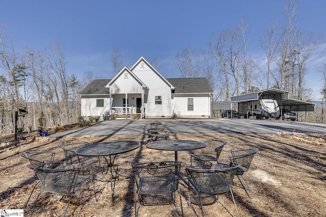 rear view of house featuring a detached carport, crawl space, and roof with shingles