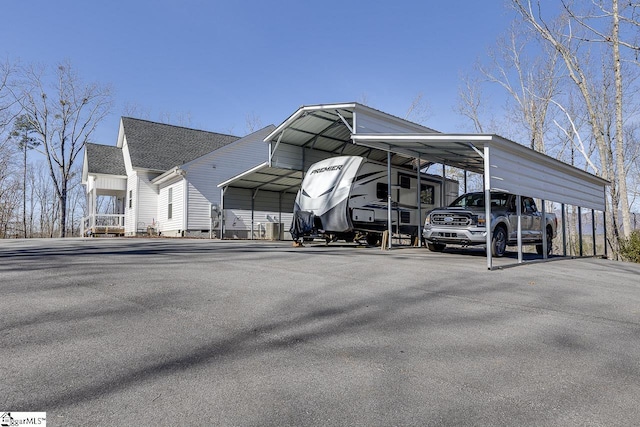 view of vehicle parking featuring a carport and asphalt driveway