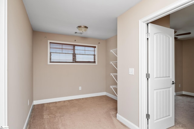 empty room featuring light carpet and baseboards