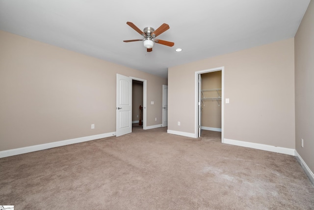 unfurnished bedroom with a walk in closet, baseboards, light colored carpet, recessed lighting, and a closet