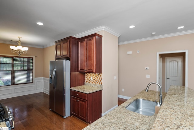 kitchen featuring appliances with stainless steel finishes, a sink, dark wood-style flooring, a chandelier, and ornamental molding