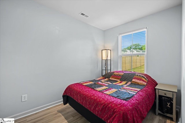 bedroom featuring wood finished floors and baseboards