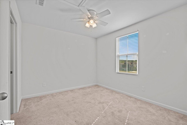 carpeted spare room with ceiling fan and baseboards