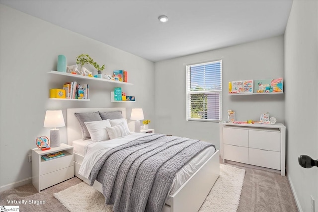 bedroom featuring light carpet and baseboards