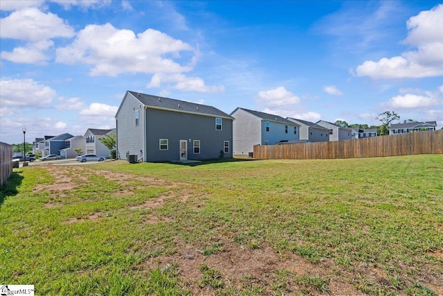 rear view of house with a residential view, fence, and central air condition unit