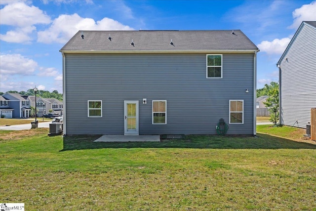 rear view of house with a patio and a lawn