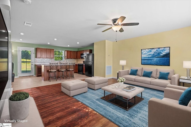living area with light wood-style floors, a ceiling fan, recessed lighting, and baseboards