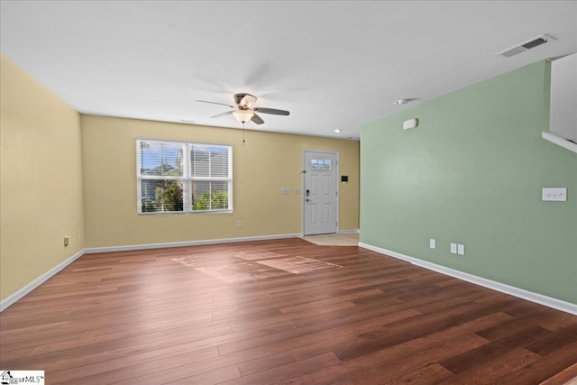 unfurnished living room featuring a ceiling fan, wood finished floors, and baseboards