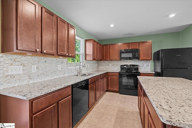 kitchen with black appliances, a sink, backsplash, light stone counters, and recessed lighting