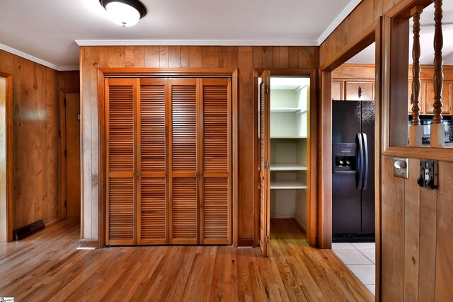 200 Lavonne Ave, Easley, SC 29642 - interior space featuring black fridge with ice dispenser, crown molding, light wood-type flooring, wooden walls, and baseboards