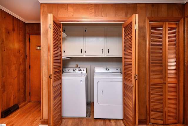 200 Lavonne Ave, Easley, SC 29642 - laundry area featuring cabinet space, separate washer and dryer, light wood finished floors, ornamental molding, and wooden walls