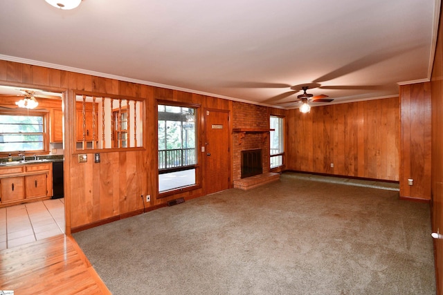 200 Lavonne Ave, Easley, SC 29642 - unfurnished living room with ornamental molding, ceiling fan, healthy amount of natural light, wood walls, and a fireplace