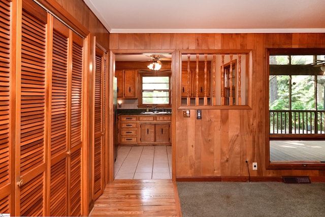 200 Lavonne Ave, Easley, SC 29642 - kitchen with crown molding, wooden walls, a sink, brown cabinets, and dark countertops