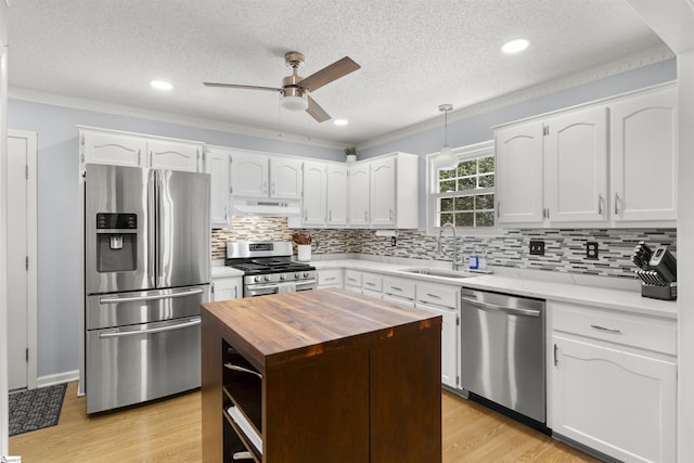 kitchen featuring appliances with stainless steel finishes, wood counters, a sink, ceiling fan, and light wood finished floors