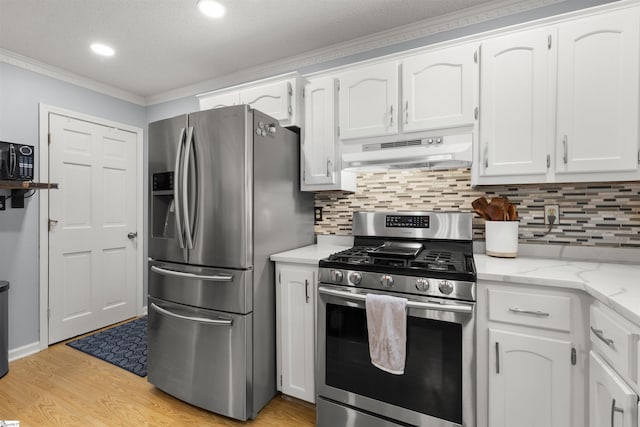 kitchen featuring stainless steel appliances, under cabinet range hood, crown molding, white cabinets, and backsplash