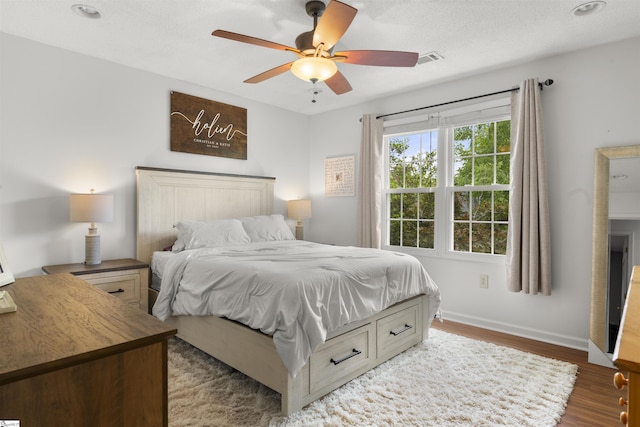 bedroom with dark wood finished floors, baseboards, and ceiling fan