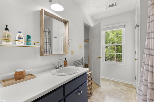 bathroom with a textured ceiling and vanity