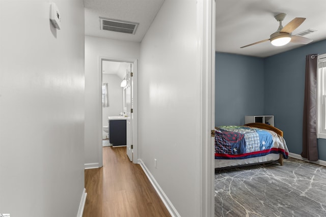 hallway with baseboards, wood finished floors, and plenty of natural light