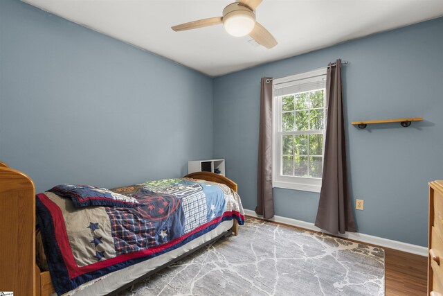 bedroom with wood finished floors, baseboards, and ceiling fan