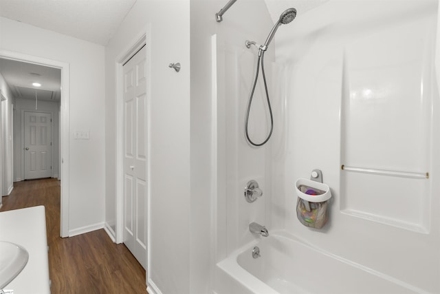 full bath featuring wood finished floors, tub / shower combination, and baseboards