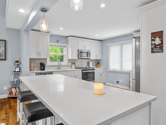 702 Lakewinds Blvd, Inman, SC 29349 - kitchen with stainless steel appliances, a sink, baseboards, tasteful backsplash, and white cabinets