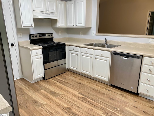 kitchen with appliances with stainless steel finishes, under cabinet range hood, a sink, light wood-type flooring, and white cabinets