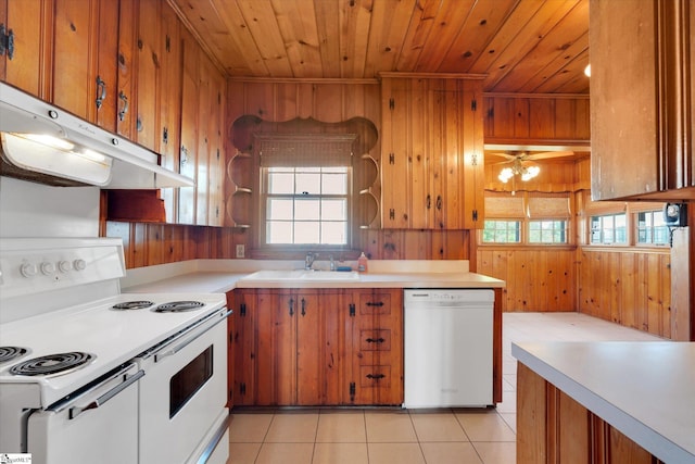 kitchen with white appliances, wooden walls, a sink, wooden ceiling, and brown cabinets