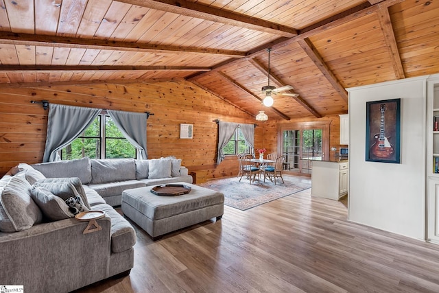 living room with wood ceiling, plenty of natural light, wood walls, light wood-type flooring, and ceiling fan