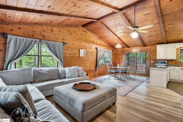 living area with wood ceiling, wooden walls, light wood-type flooring, and ceiling fan