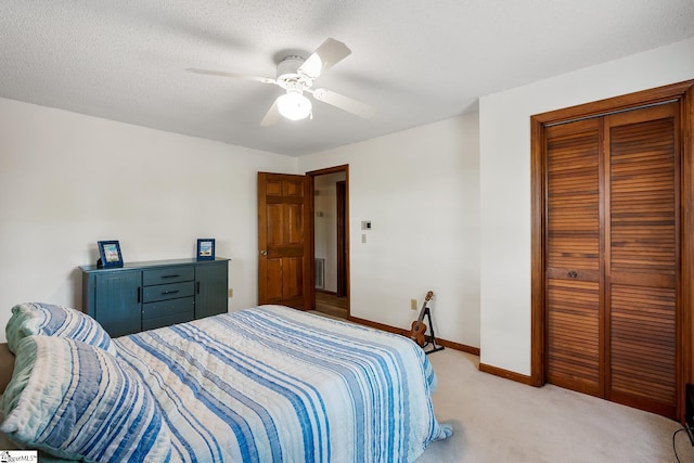 bedroom with light carpet, a closet, ceiling fan, and baseboards