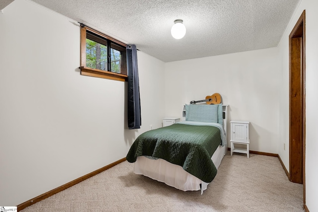 bedroom featuring a textured ceiling, carpet, and baseboards