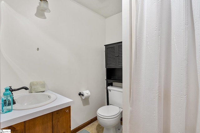 full bath featuring toilet, vanity, and baseboards