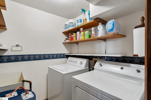 laundry area with washer and clothes dryer and a textured ceiling