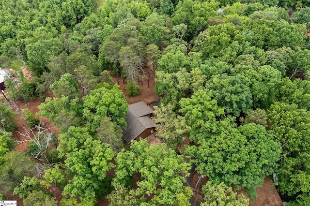 aerial view of property and surrounding area featuring a heavily wooded area