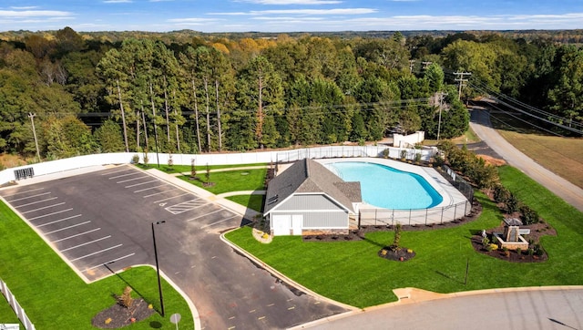 drone / aerial view of a forest and a pool area