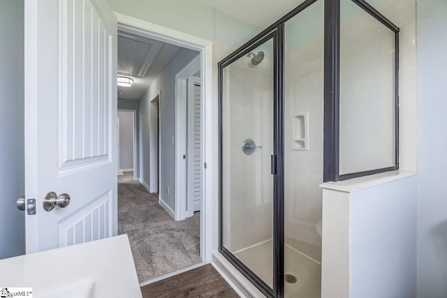 bathroom with a shower stall and wood finished floors