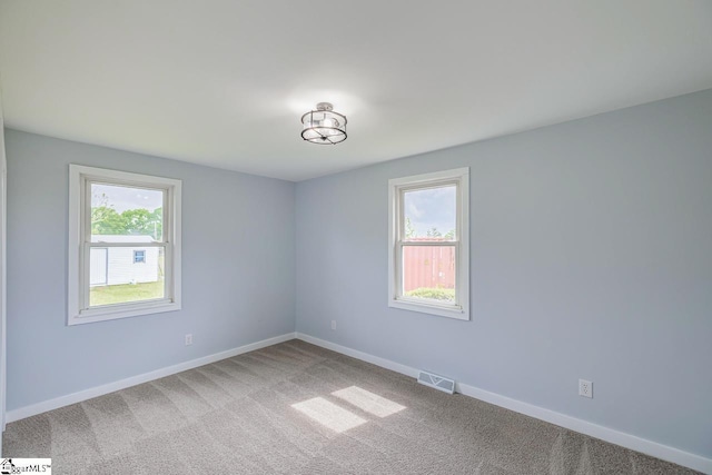 unfurnished room with carpet flooring and baseboards