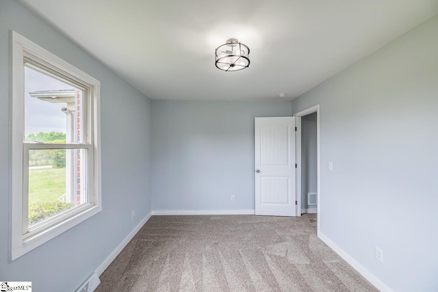 carpeted empty room with baseboards