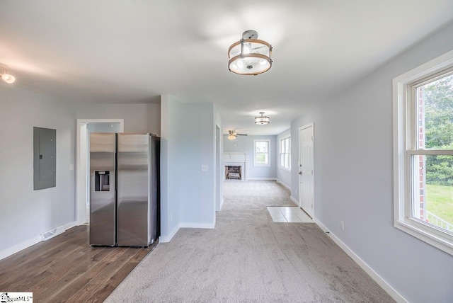 hall with electric panel, baseboards, and wood finished floors