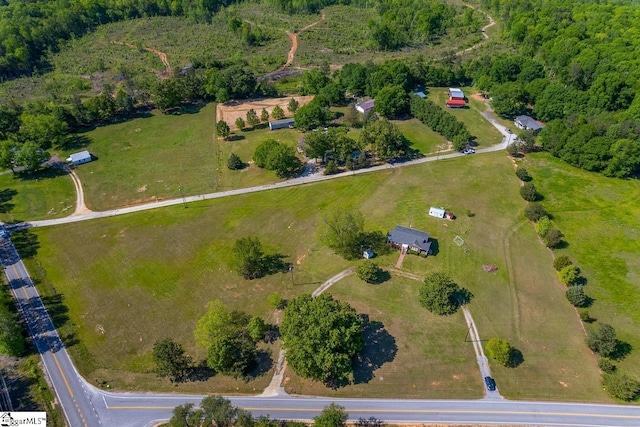 view of property location with a forest