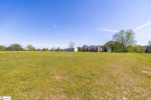 view of green lawn featuring a view of rural / pastoral area