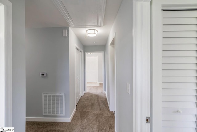 corridor featuring attic access, carpet floors, and baseboards