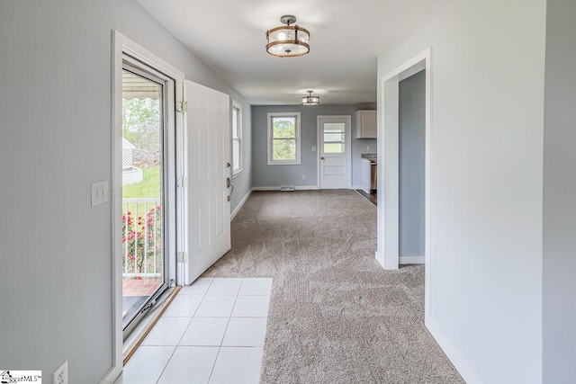 corridor featuring light colored carpet and baseboards