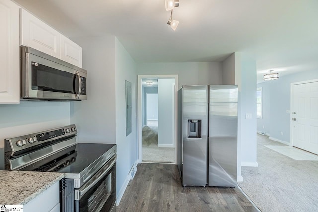 kitchen with appliances with stainless steel finishes, white cabinets, dark wood-style floors, and baseboards
