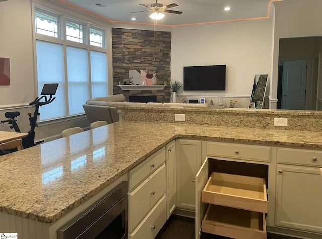 920 Hunterdale Ln, Boiling Springs, SC 29316 - kitchen with stainless steel microwave, open floor plan, ceiling fan, ornamental molding, and light stone counters