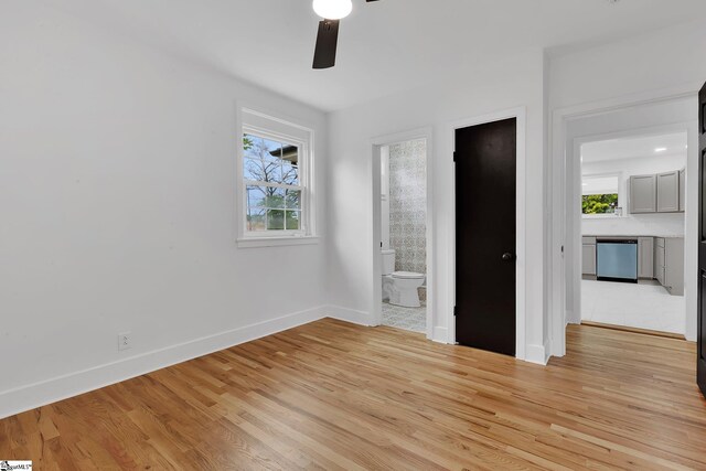 3902 Old Buncombe Rd, Greenville, SC 29617 - unfurnished bedroom featuring baseboards, light wood-type flooring, ensuite bath, and a ceiling fan