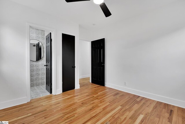 3902 Old Buncombe Rd, Greenville, SC 29617 - unfurnished bedroom with wood finished floors, baseboards, a ceiling fan, and connected bathroom