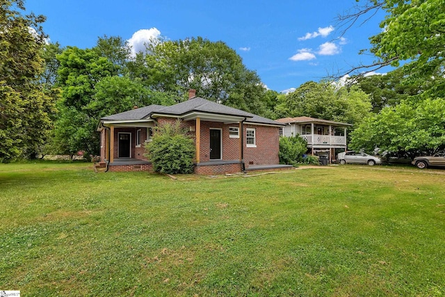 3902 Old Buncombe Rd, Greenville, SC 29617 - view of front of house with a front yard, a chimney, brick siding, and covered porch